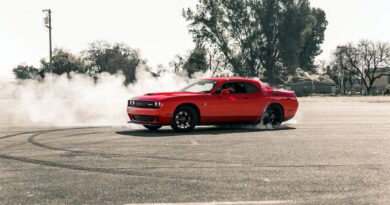 red coupe drifting on asphalt road